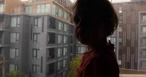 Curious kid looking away in window Stock Footage 99712580