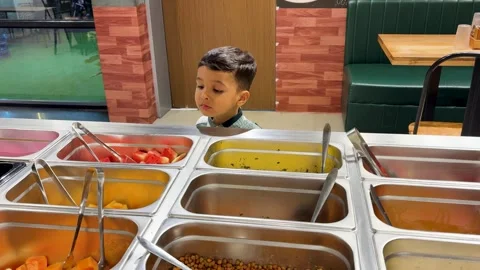 Curious Kid Looking at Buffet Food Selection in Casual Dining Restaurant Stock Footage 336981637