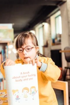 Curious kid with problems with health dealing with new book 写真素材