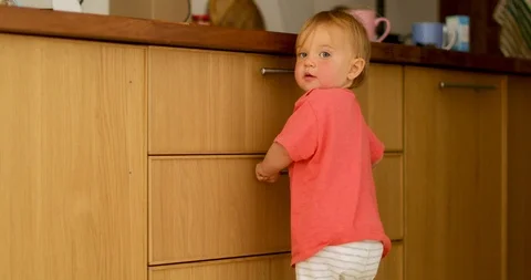 Curious kid standing leaning kitchen drawer Stock Footage 112003461