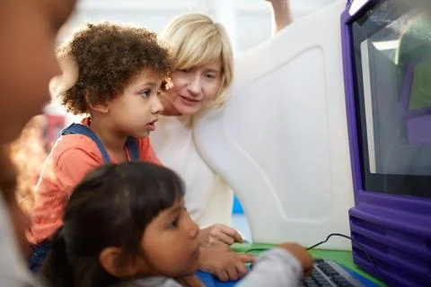 Curious kids using computer in science center Stock Photos