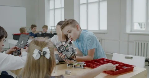 Curious kids working on a programable robot during robotics class at school Stock Footage 108867711