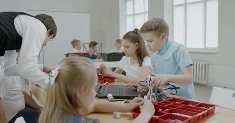 Curious kids working on a programable robot during robotics class at school Stock Footage 108868046