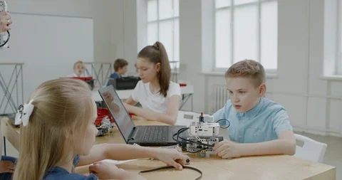 Curious kids working on a programable robot during robotics class at school Stock Footage 108869967