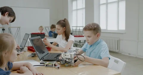 Curious kids working on a programable robot during robotics class at school Stock Footage 108871053