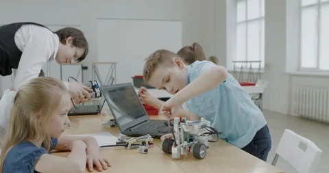 Curious kids working on a programable robot during robotics class at school Stock Footage 108871817