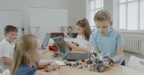 Curious kids working on a programable robot during robotics class at school Stock Footage 108872680