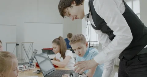 Curious kids working on a programable robot during robotics class at school Stock Footage 108873587