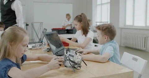 Curious kids working on a programable robot during robotics class at school Stock Footage 108873999