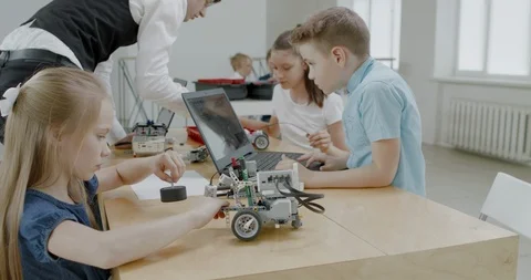 Curious kids working on a programable robot during robotics class at school Stock Footage 108874769