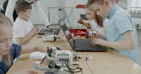 Curious kids working on a programable robot during robotics class at school Stock Footage 108874993