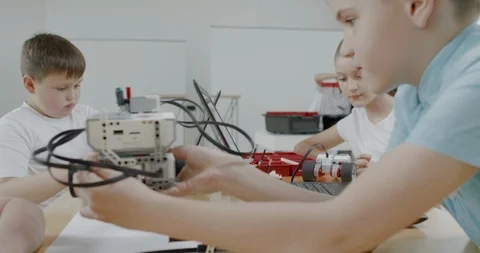 Curious kids working on a programable robot during robotics class at school Stock Footage 108875308