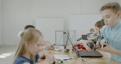 Curious kids working on a programable robot during robotics class at school Stock Footage 108876197