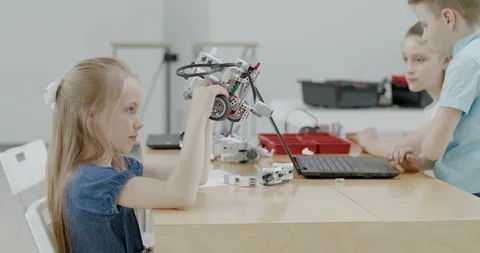 Curious kids working on a programable robot during robotics class at school Stock Footage 108877091