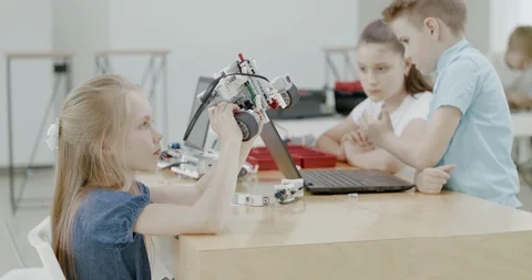 Curious kids working on a programable robot during robotics class at school Stock Footage 108877505