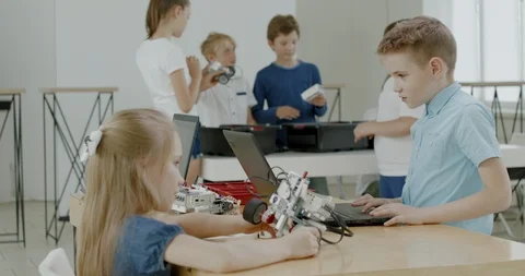 Curious kids working on a programable robot during robotics class at school Stock Footage 108877687