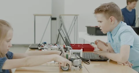 Curious kids working on a programable robot during robotics class at school Stock Footage 108878904