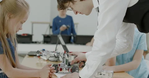 Curious kids working on a programable robot during robotics class at school Video stock 108879021