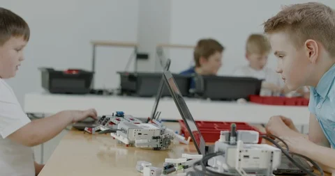 Curious kids working on a programable robot during robotics class at school Video stock 108879578