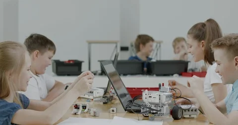 Curious kids working on a programable robot during robotics class at school Video stock 108879808