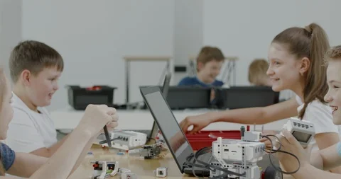 Curious kids working on a programable robot during robotics class at school Video stock 108879953