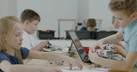 Curious kids working on a programable robot during robotics class at school Video stock 108880278