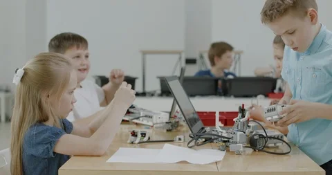 Curious kids working on a programable robot during robotics class at school Video stock 108880521