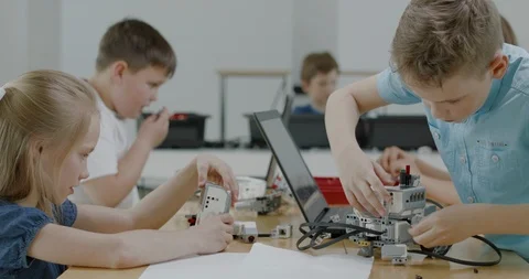 Curious kids working on a programable robot during robotics class at school Video stock 108880746