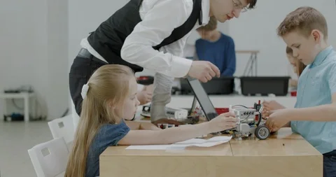 Curious kids working on a programable robot during robotics class at school Video stock 108880968