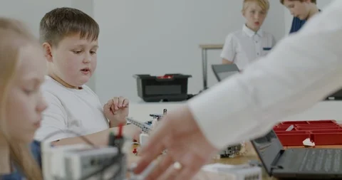 Curious kids working on a programable robot during robotics class at school Video stock 108881132
