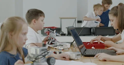 Curious kids working on a programable robot during robotics class at school Video stock 108881240