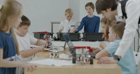 Curious kids working on a programable robot during robotics class at school Video stock 108881312