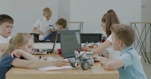 Curious kids working on a programable robot during robotics class at school Video stock 108883156