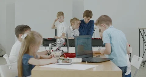 Curious kids working on a programable robot during robotics class at school Video stock 108884216