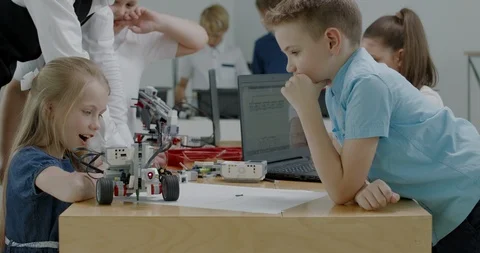 Curious kids working on a programable robot during robotics class at school Video stock 108884460
