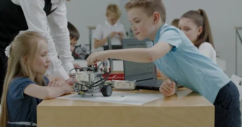 Curious kids working on a programable robot during robotics class at school Video stock 108884635