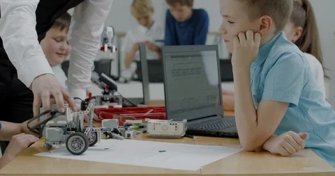 Curious kids working on a programable robot during robotics class at school Stock Footage 108884744
