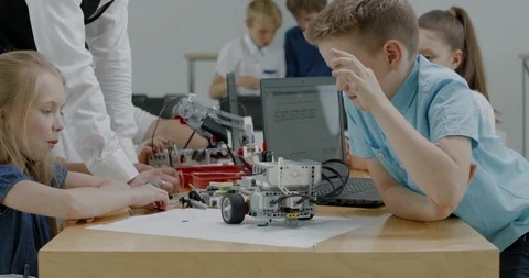 Curious kids working on a programable robot during robotics class at school Video stock 108885043