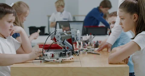 Curious kids working on a programable robot during robotics class at school Video stock 108885518