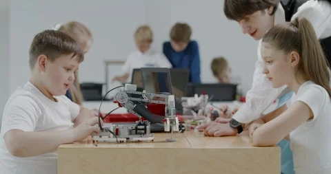 Curious kids working on a programable robot during robotics class at school Video stock 108888364