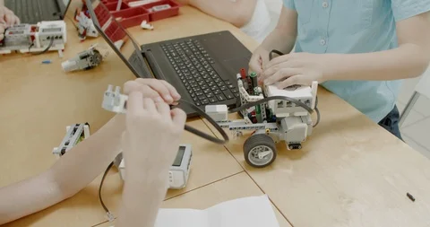 Curious kids working on a programable robot during robotics class at school Video stock 108889208