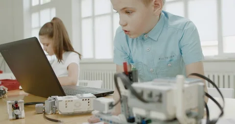 Curious kids working on a programable robot during robotics class at school Video stock 108889346