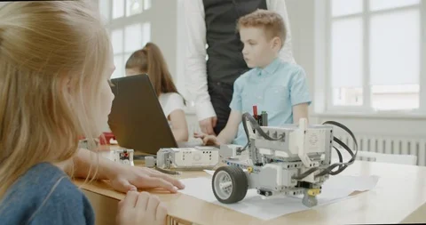 Curious kids working on a programable robot during robotics class at school Video stock 108889467
