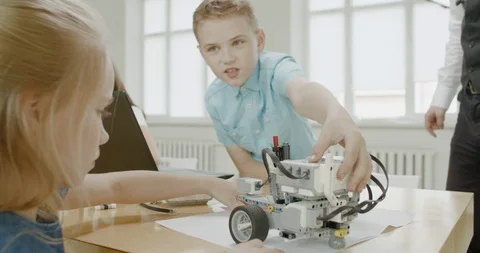 Curious kids working on a programable robot during robotics class at school Video stock 108889911