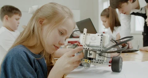Curious kids working on a programable robot during robotics class at school Video stock 108890169