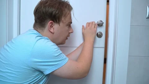 Curious man peering through door, engaged in intriguing discovery Stock Footage 294459413