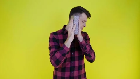 Curious man shakes box with gift near ear and tries to understand what's inside Stock Footage 134600839