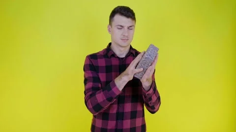 Curious man shakes box with gift near ear and tries to understand what's inside Stock Footage 135900694