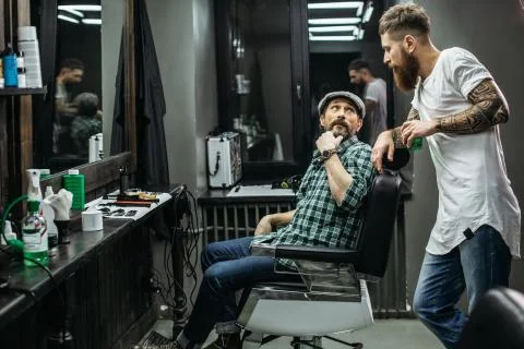 Curious man turning while talking to the barber Stock Photos