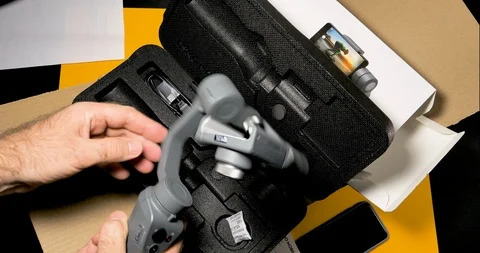 Curious man unpacking and setting DJI Osmo Mobile 2 Smartphone Gimbal Video stock 100821089